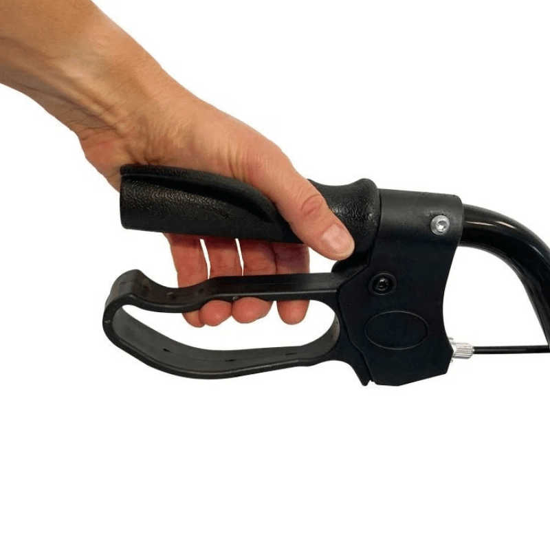 Pormenor de uma mão a segurar o punho ergonómico preto e a alavanca do travão de um andarilho