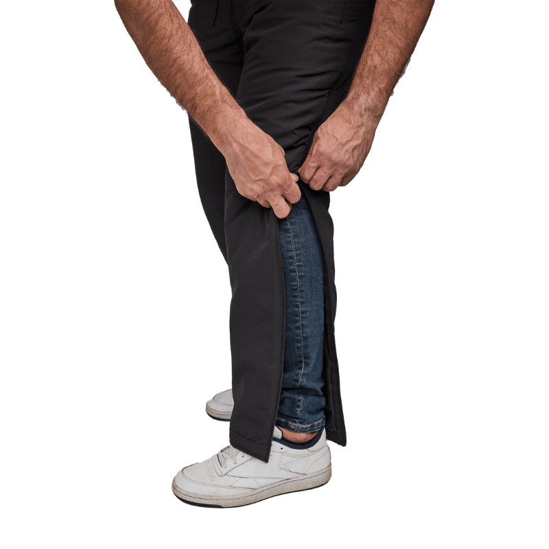 Close-up de mãos a desabotoar calças térmicas Dobsom lateralmente sobre jeans