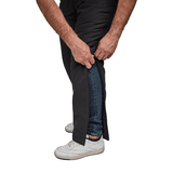 Close-up de mãos a desabotoar calças térmicas Dobsom lateralmente sobre jeans